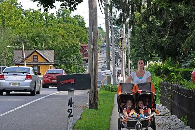 File photo: A woman pushes her children down Main Street in the beautiful community of Mullica Hill, NJ, on Aug. 5, 2013.  (APRIL SAUL / Staff)