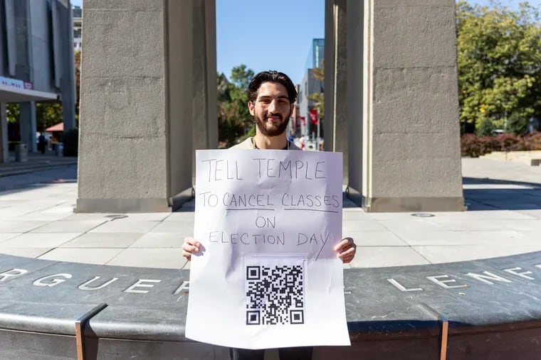 Jared Goldberg, 21, a Temple senior studying political science, at the Bell Tower on Temple’s campus holding a sign for students to sign a petition, in Philadelphia Friday. The petition is a proposal to tell Temple to give students a day off to go vote and help the community on Election Day.