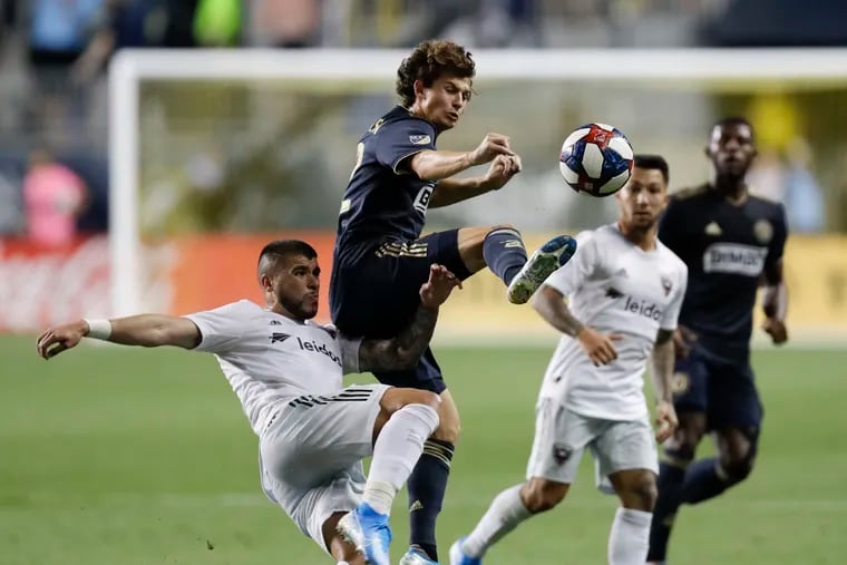 Union midfielder Brenden Aaronson gets ahead of D.C. United's Ulises Segura in pursuit of the ball during the first half.