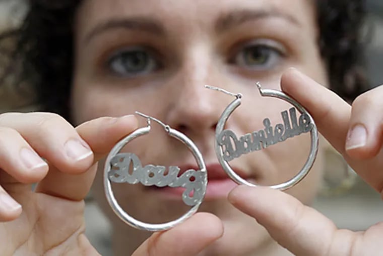 Danielle Hummel’s earrings bearing her name and that of a former flame are unwearable, but she's hesitant to sell them. (Bonnie Weller/Inquirer)