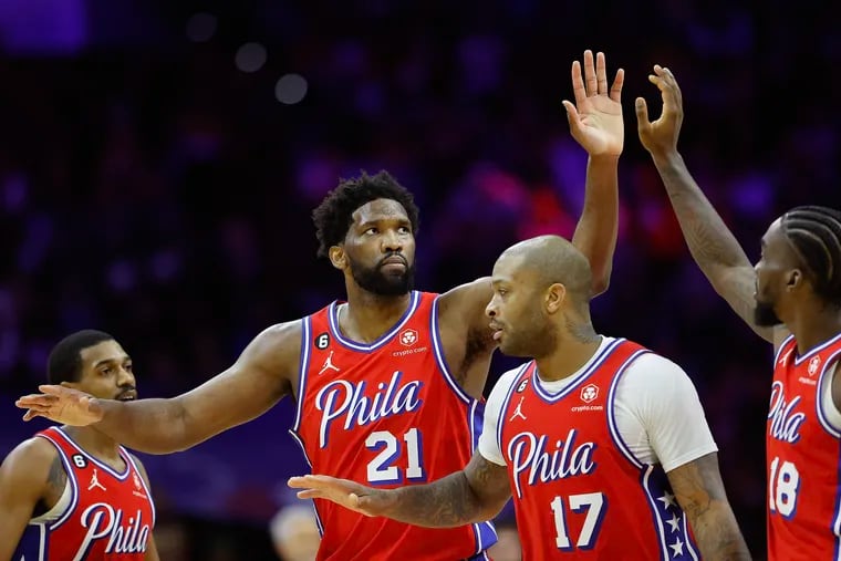Sixers center Joel Embiid high-fiving teammates late in the fourth quarter Friday against the Golden State Warriors. Embiid and the Sixers are on a four-game winning streak.