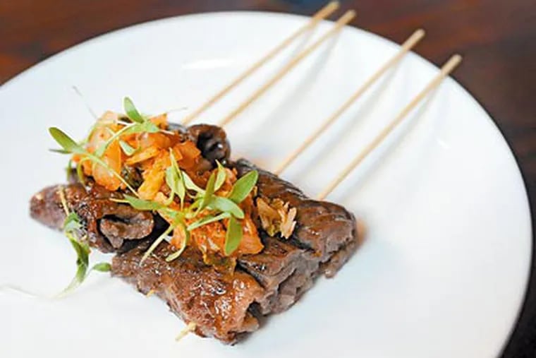 The small-plates at Sampan in Midtown Village include crab "egg roll," peking duck, tuna sashimi and, above, Korean bbq beef skewers. (Clem Murray / Staff Photographer)