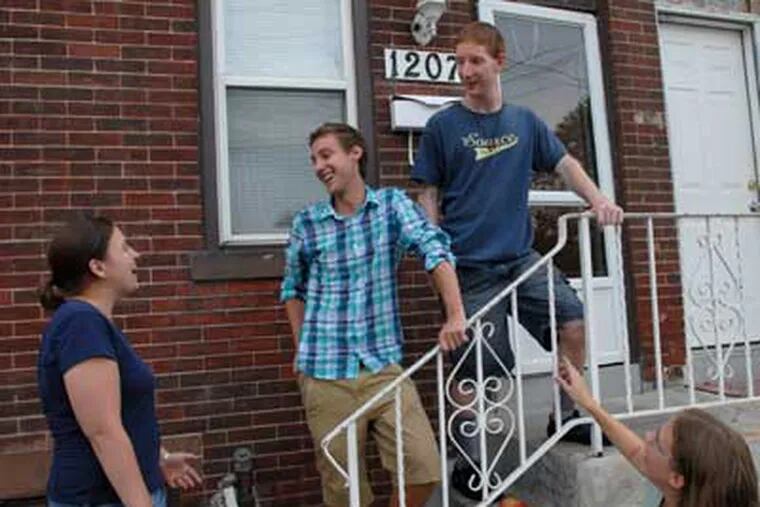 College grads who live in Camden. Joshua Dupuis, a Franciscan volunteer, second from left, talks to his roommates Colleen McTammany, left, and Tom Firme, top right.  At bottom right is Jennifer Midura.  ( April Saul / Staff Photographer )
