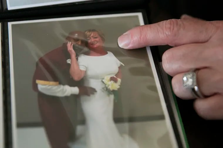 Karen Brookins, wife of John Brookins, points to their wedding photo from State Correctional Institution Phoenix inside her home in Levittown.