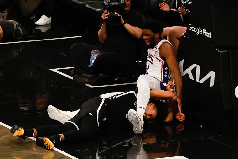 Sixers center Joel Embiid falls over Brooklyn Nets forward Cameron Johnson. He suffered an LCL sprain in his right knee in the April 20 game.
