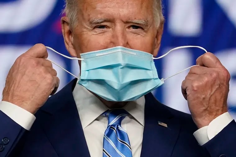 Democratic presidential candidate former Vice President Joe Biden takes off his face mask as he arrives to speak, Wednesday in Wilmington, Del.