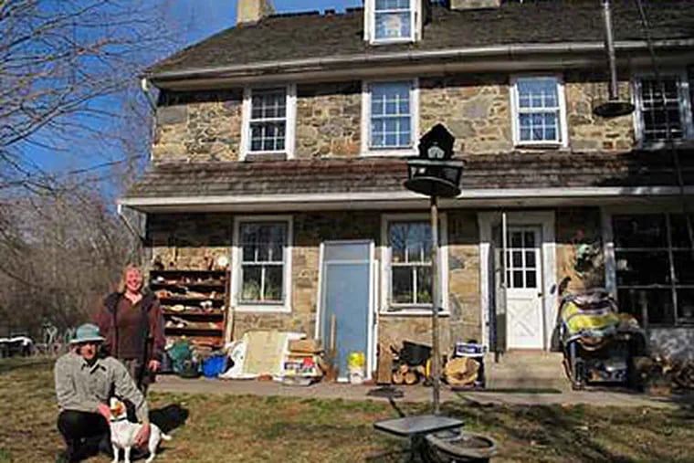 In one of the 24 coveted rental homes dotting Ridley Creek State Park, Warren Graham and Cecile Mann - with their dog Zoe - handle upkeep and critter visits. 'The house was quite neglected,' said Graham, 'but we have begun to resurrect it.' (Mari A. Schaefer/Staff)