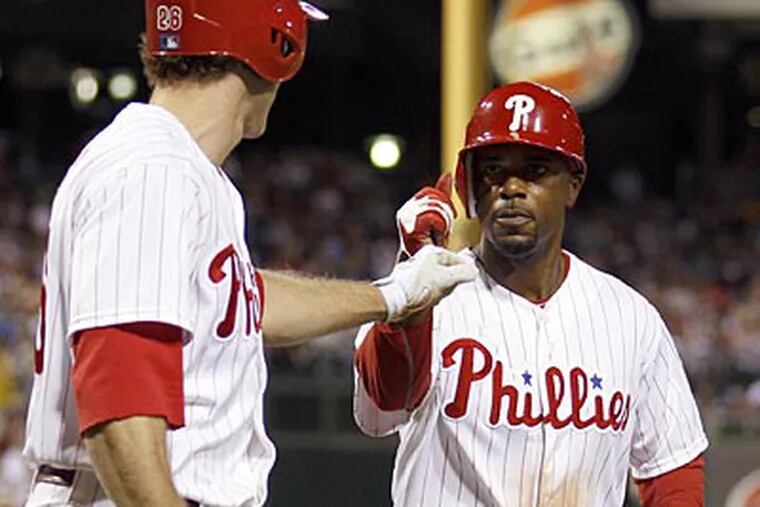 Jimmy Rollins celebrates his fifth-inning run against the Marlins with Chase Utley. (Yong Kim/Staff Photographer)