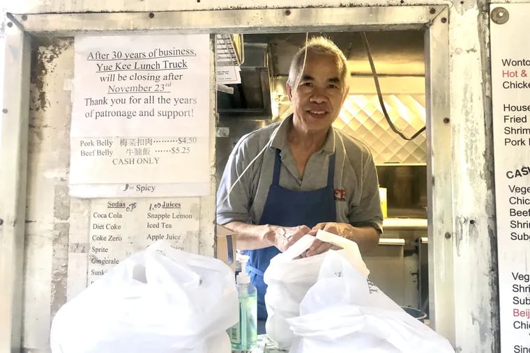 Chef and co-owner Tsz Pong peaks out of the takeout window at Yue Kee, the Chinese food truck he ran with his wife Bi Pang across from Wharton that is closing after 37 years. He removed his mask briefly for the portrait.