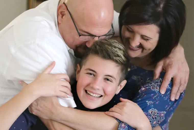 Mason Catrambone with parents Frank Catrambone and Annmarie Kita. The couple have embraced their 14-year-old as a transgender person, but Camden Catholic High, citing its beliefs, has not.