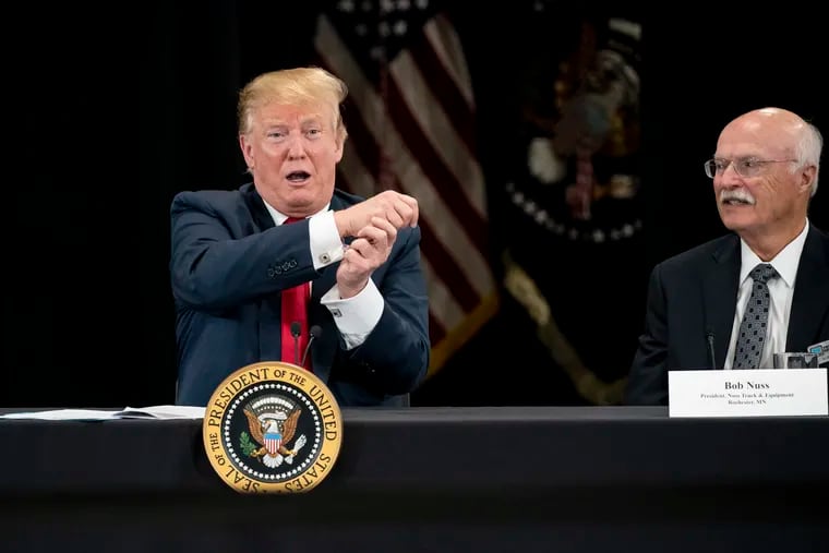 FILE photo shows President Donald J. Trump pretending to wave a flag as he speaks at Nuss Truck and Equipment in Burnsville during a roundtable discussion on tax cuts and the U.S. economy in Burnsville, Minn. At right is the president of Nuss Truck and Equipment Bob Nuss. (Renee Jones Schneider/Minneapolis Star Tribune/TNS)