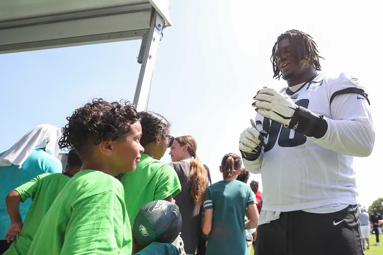 Eagles defensive tackle Jordan Davis signs autographs after practice on the second day of open training camp at the NovaCare Complex in Philadelphia on Friday, July 28, 2023.