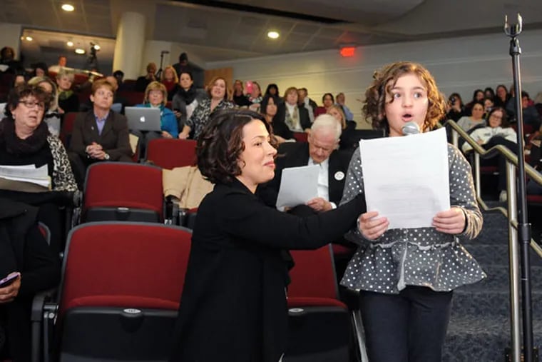 Little Angelina Chila, an 8-year-old third grader at Hurffville Elementary School, addresses the commission at Camden County College in Blackwood on Feb. 19, 2015. Angelina's mom, Carol, is holding the microphone. They live in Sewell. ( CLEM MURRAY / Staff Photographer )