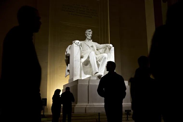 Nighttime visitors view the statue of President Abraham Lincoln at the Lincoln Memorial on Feb. 27, 2018, in Washington, D.C.