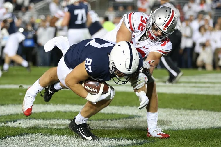 Penn State tight end/halfback Pat Freiermuth (87) makes a touchdown reception under pressure from Ohio State linebacker Tuf Borland last September. Penn State lost 27-26.