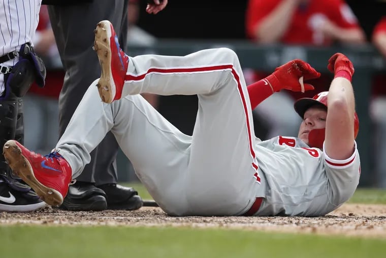 The Phillies' Rhys Hoskins gets up after getting hit by a pitch from Colorado Rockies reliever Adam Ottavino in the eighth inning.