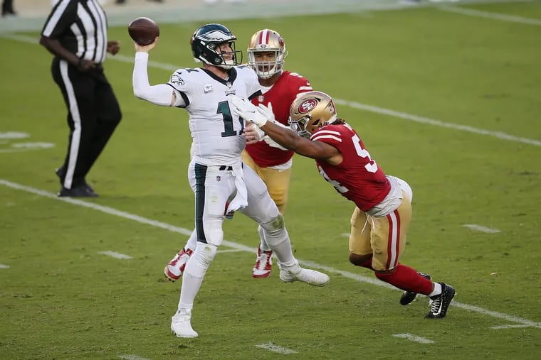 San Francisco 49ers defensive lineman Arik Armstead (91) and linebacker Fred Warner (54) pressure Eagles quarterback Carson Wentz in the second quarter of Sunday's game.