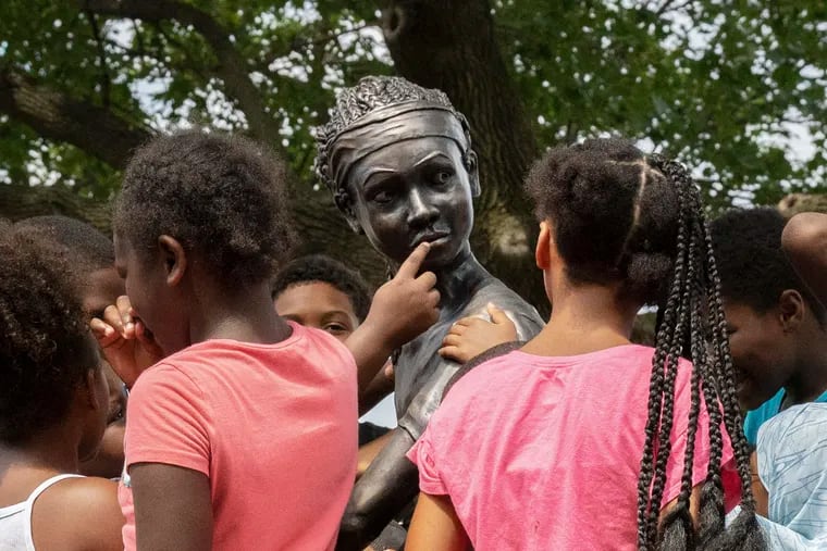 Young kids at the park run up to statue after the unveiling portraying a young African American girl basketball player, by artist Brian McCutcheon,  its the first statue of a black girl in the city at Smith Playground in South Philadelphia, on Wednesday, July 31, 2019.