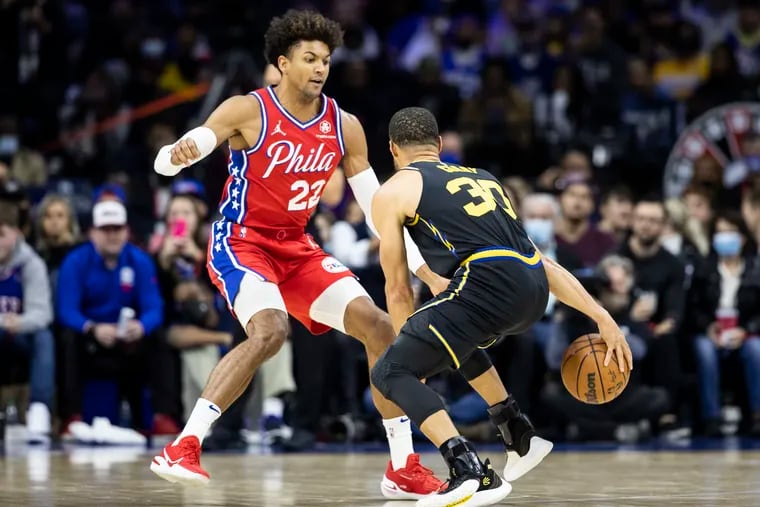 Matisse Thybulle, left, of the Sixers plays defense against Stephen Curry of the Warriors during the 1st half of their game at the Wells Fargo Center on Dec. 11, 2021.