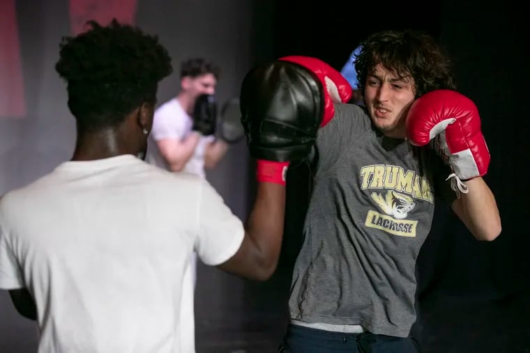 Aidan Kinniry, right, who will play Rocky, spars with Wa’kee Giddens while training on stage inside the auditorium of Harry S Truman High School in Levittown, PA on Tuesday, Feb. 22, 2022. Truman High School will do the post-Broadway world premiere of the musical Rocky. The show will be performed on March 3rd, 4th and 5th at the high school. Several of the students received boxing lessons in order to prepare for the musical.