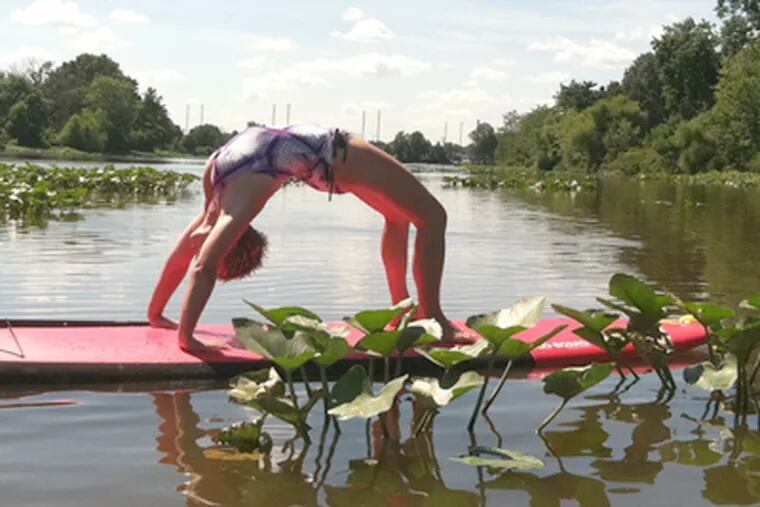 Michele Wade takes paddleboarding up a level, demonstrating a half-wheel yoga pose. For most, merely standing upright is a challenge. (Art Carey / Staff)