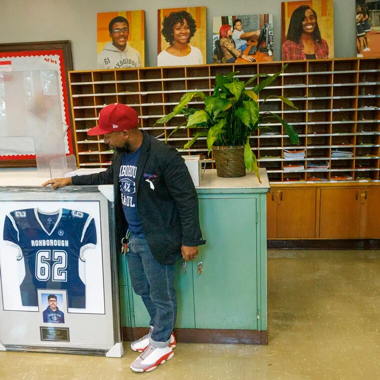Julian Saavedra, Assistant Principal,  Academies at Roxborough in Philadelphia, with framed football jersey and picture of Nicolas Elizalde. Elizalde was shot and killed one year ago after a football scrimmage. A moment of silence was held at the school on Wednesday.