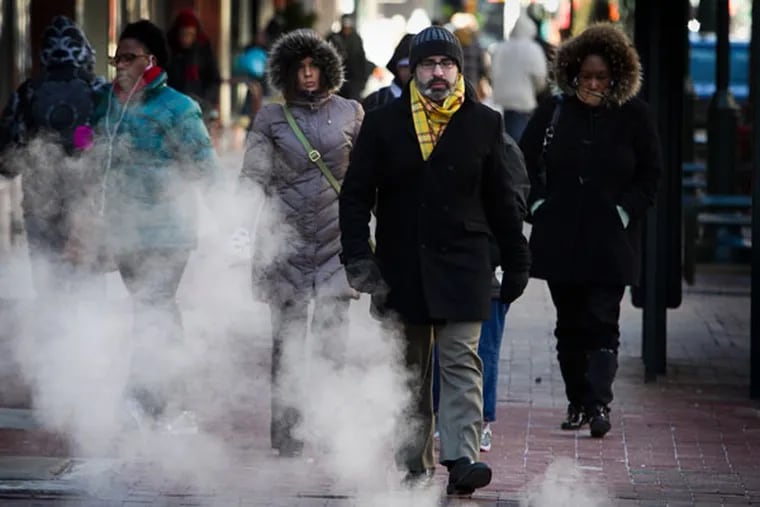 Pedestrians along Market St. at 7th a bundled up and ready for the single digit temperatures in Philadelphia. The steam vents at this intersection create large clouds as the warm air mixes with colder temperatures in Philadelphia on Tuesday, January 7, 2014. A polar vortex from the north dropped temperatures in the region to single digits. ( ALEJANDRO A. ALVAREZ / STAFF PHOTOGRAPHER )