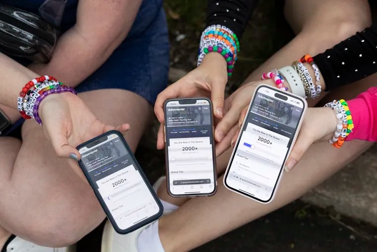 From left: Anna Mason, Emily Lind and Kristen Robinson show their Ticketmaster queue from the parking lot outside of the Taylor Swift concert in Philadelphia on May 13, 2023.