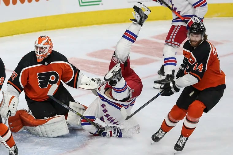 Rangers' Libor Hajek takes header between Flyers' goalie Brian Elliott and Sean Couturier during the second period at the Wells Fargo Center in Philadelphia, Wednesday,  February 24, 2021.