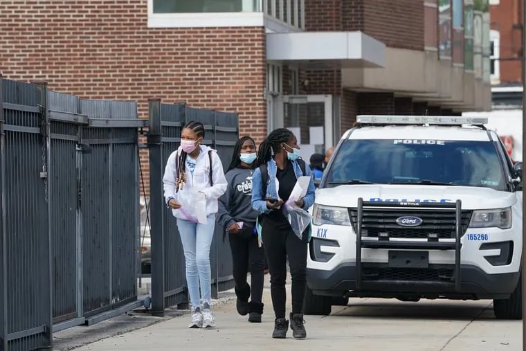 Students leave the Philadelphia Learning Academy-South in West Philadelphia on Friday after a student shot himself in the leg inside the building.