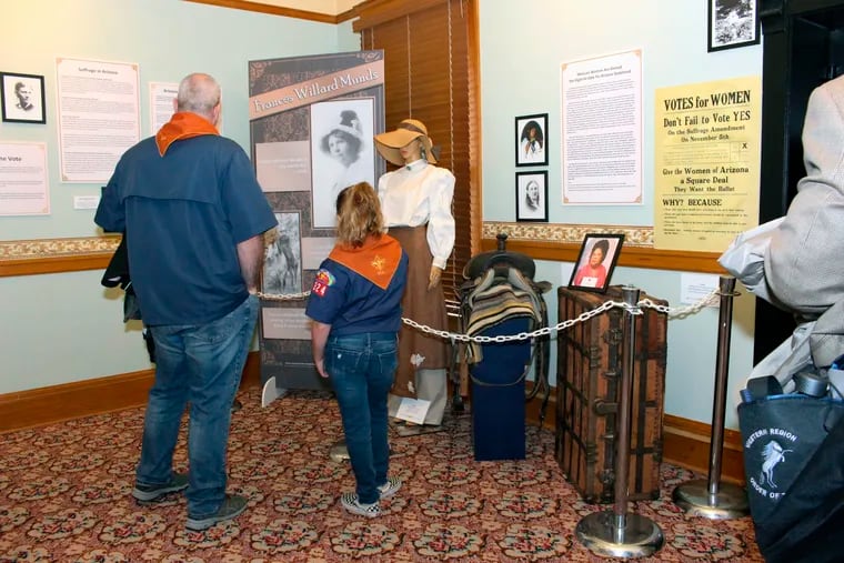 Visitors to the Arizona Capitol Museum in Phoenix look at a display honoring the state’s early suffrage movement.