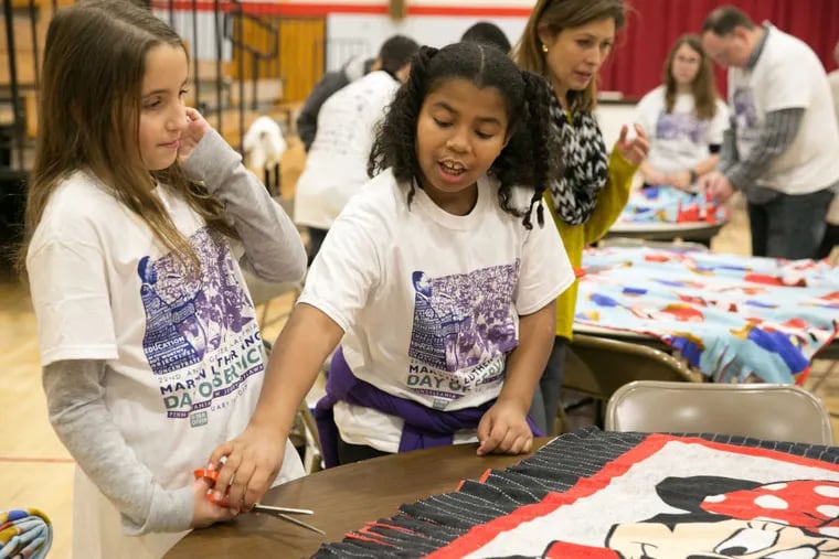 Gabrielle Achinko, 9, left, and Jameela Gibbs, 9, second from left, modify blankest by combining two blankets in order to donate the blankets to the Camden County Women&#039;s Shelter, during Martin Luther King Day of Service, at Charles W. Lewis Middle School, in Gloucester Township, New Jersey, January 16,  2017.