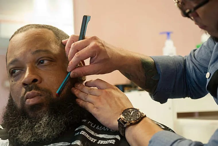 Carl Adams has his beard trimmed by stylist Sergio Delgado in the Beauty in Transition traveling salon. MICHAEL PRONZATO / Staff Photographer
