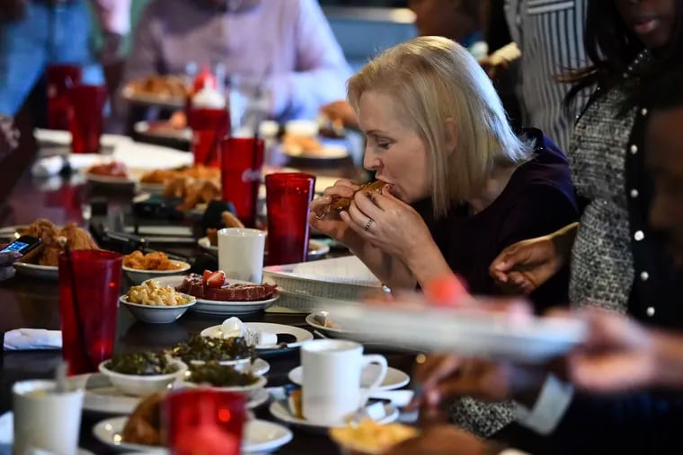 In this Saturday, Feb. 9, 2019, photo Sen. Kirsten Gillibrand eats at Kiki’s Chicken and Waffles in Columbia, S.C. Gillibrand spent three days in the state as part of her effort to introduce her potential presidential campaign to the state’s heavily African-American Democratic primary electorate.