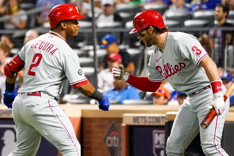 The Phillies' Jean Segura (2) celebrates with Bryce Harper (3) after hitting a solo home run during the first inning against the New York Mets, Saturday, Sept. 18, 2021, in New York.