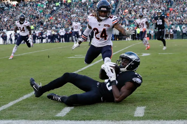 Eagles wide receiver Nelson Agholor rolling on the ground after catching the football past Chicago Bears cornerback Buster Skrine.
