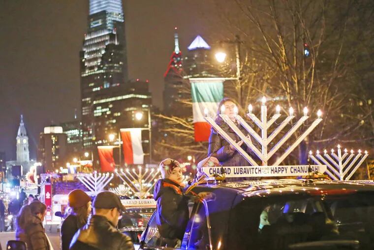 Menorahs sit on top of cars lined up along Ben Franklin Parkway before the beginning of a Hanukkah parade which ended at Independence National Park on Saturday, December 20, 2014.