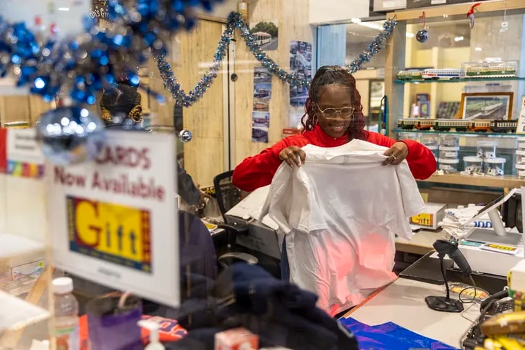 Melissa Smalls, of West Philadelphia, an e-commerce specialist, folding clothes to be put out at the SEPTA Transit Store in Philadelphia in December 2022.