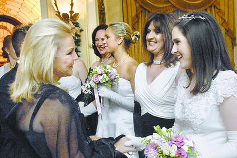 Patricia Byrns-Siganos (left) greets debutante Kelly Slota in the receiving line.