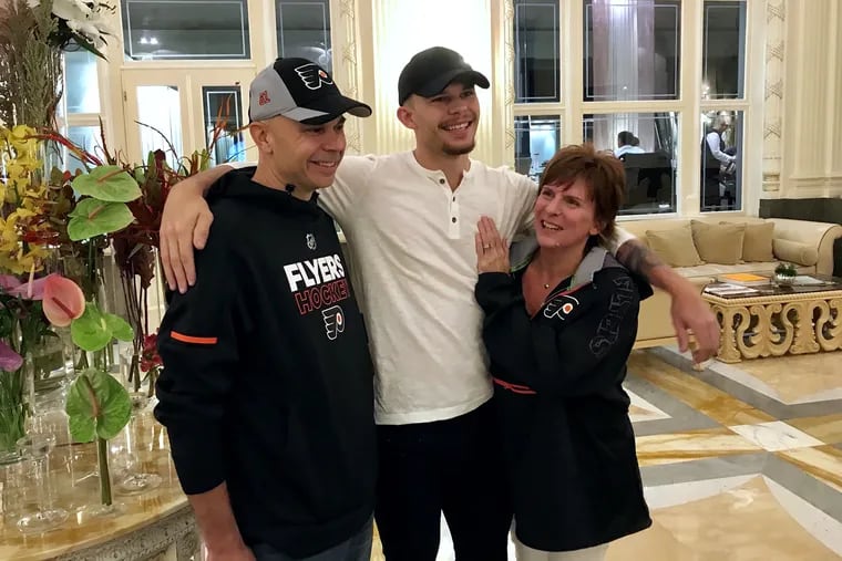Carsen Twarynski (middle), the Flyers' rookie right winger, hugs his dad, Rob, and his mom, Kim, in Prague.