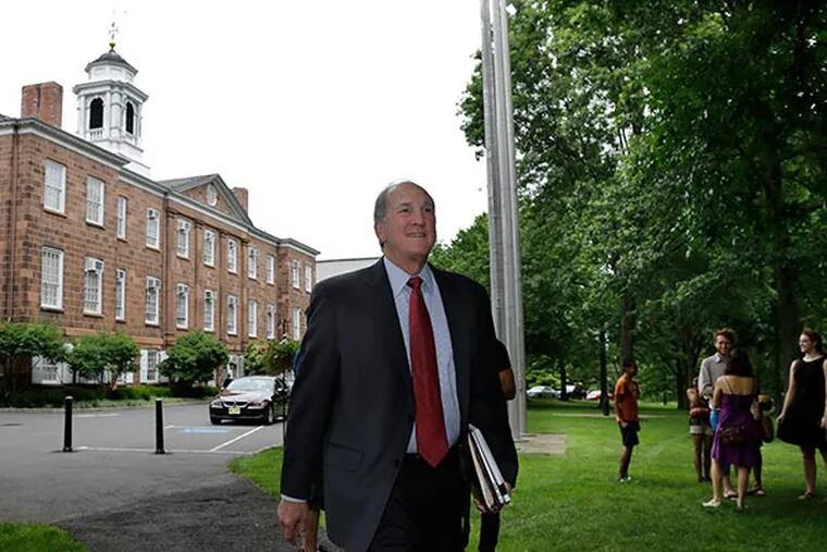 Rutgers University President Robert L. Barchi walks past students Thursday, July 11, 2013, in New Brunswick, N.J., on his way to Rutgers University's Board of Governors meeting. (AP Photo/Mel Evans)