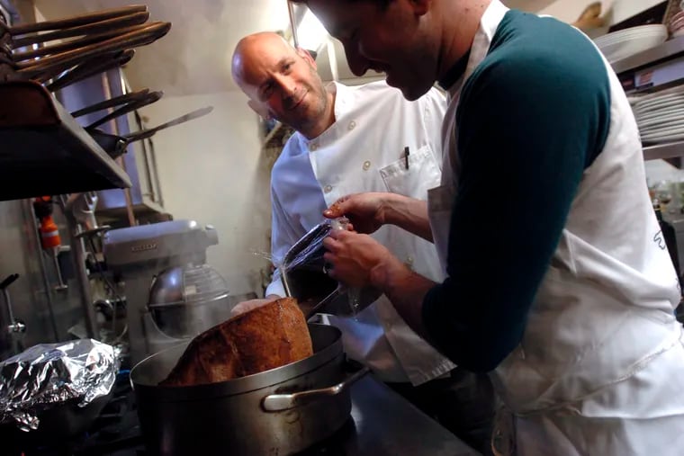 Marc Vetri (left) watches as sous chef Michael Solomonov pours some liquid into the brisket pot on the stove in the restaurant's kitchen as they prepare the Passover feast.