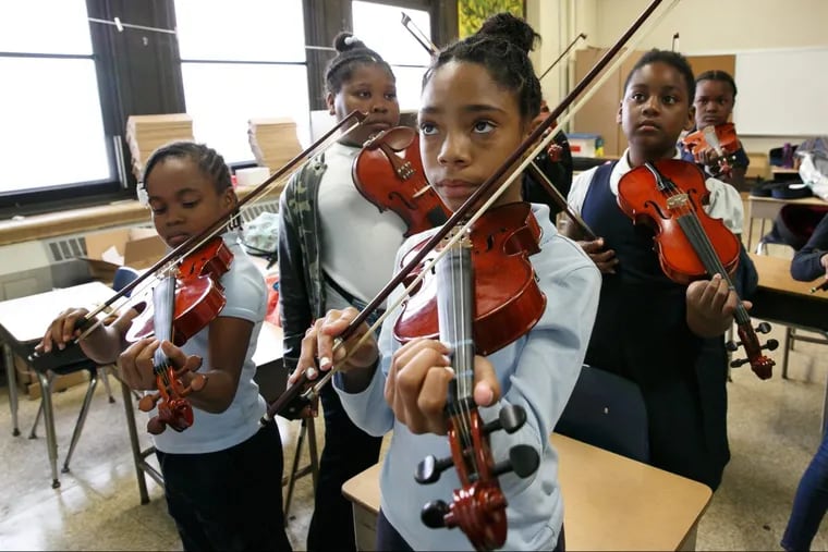 Nevaeh Wright, front center, practices the violin with her classmates at Mitchell Elementary.