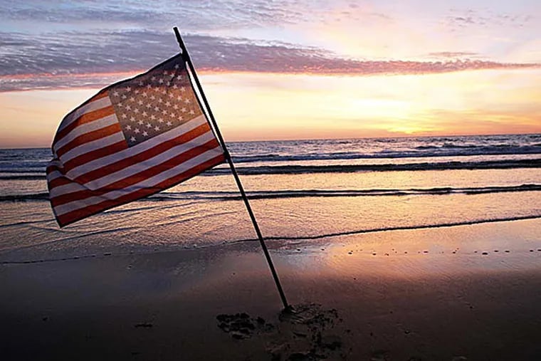 An American flag is placed in the sand of Omaha Beach in Normandy to honor the troops who participated in the invasion. (Thibault Camus/AP)