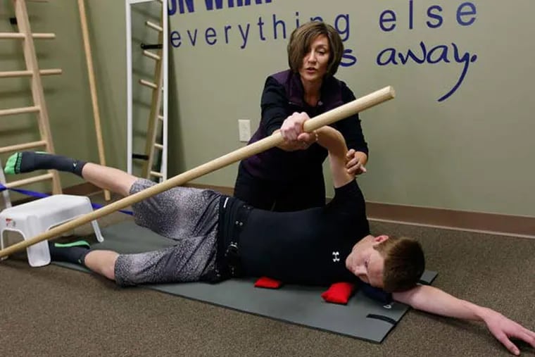 Lisa Angioli helping Trevor Johnson with certain exercises.