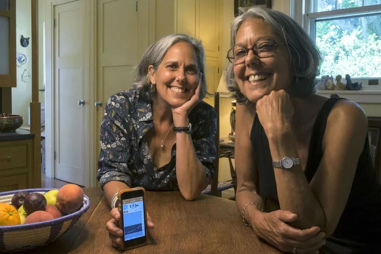 From 900 miles away, Nancy Warren (left) of Haverford can keep an eye on twin sister Kim Scharff's blood-sugar level in St. Louis via a cellphone app.