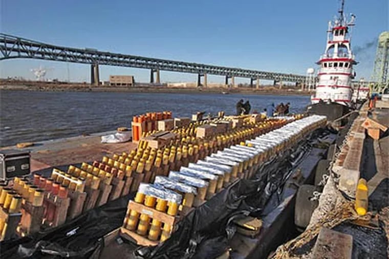 Workers from Pyrotechnico, of New Castle, Pa., prepare the fireworks for Philadelpia’s two New Year’s Eve shows on the Delaware River. The work is being done on two barges on the Delaware River located at the Navy Yard. (David M Warren / Staff Photographer)