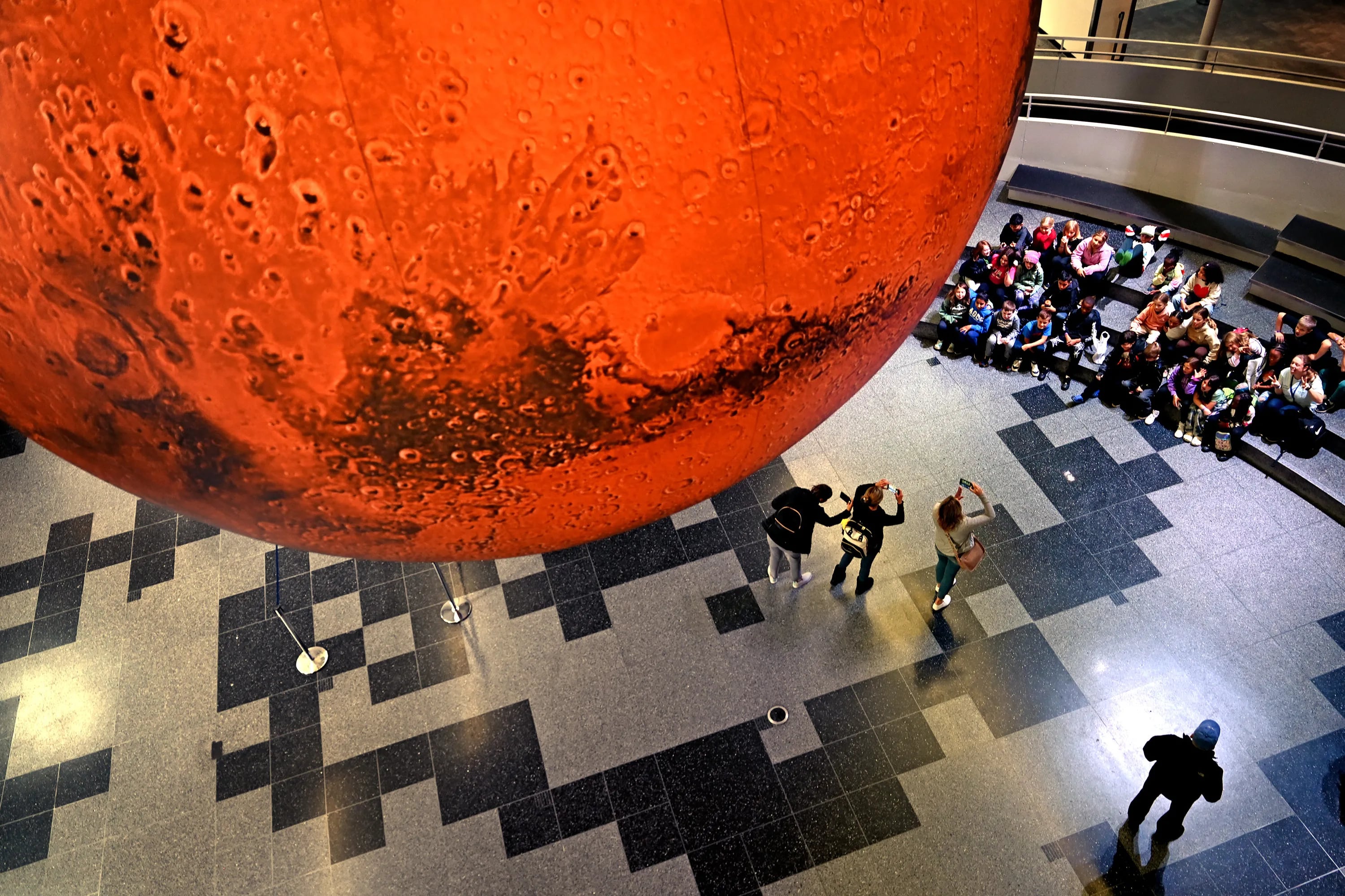 A 23 feet diameter and an approximate scale of 1:1 million, artwork of Mars by Luke Jerram brings the Red Planet close to visitors in the main lobby of the Franklin Institute Thursday, Nov. 2, 2023, as Wonderous Space  the museum’s new permanent exhibit about space exploration readies for its opening this weekend.The Mars installation uses imagery from NASA’s Mars Reconnaissance Orbiter data.