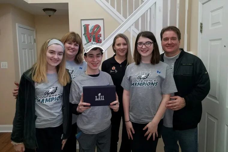 The Fitzgerald family and Mary Serie of the Minnesota nonprofit Spare Key pose with the Super Bowl tickets given to Cole, center, in the Fitzgerald family home on Monday.