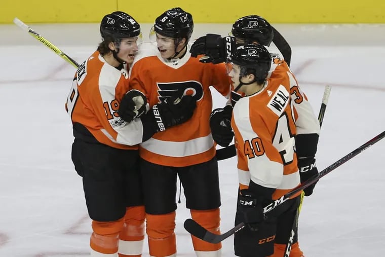 Travis Sanheim (center) celebrates with Philadelphia Flyers teammates after scoring his first NHL goal.
